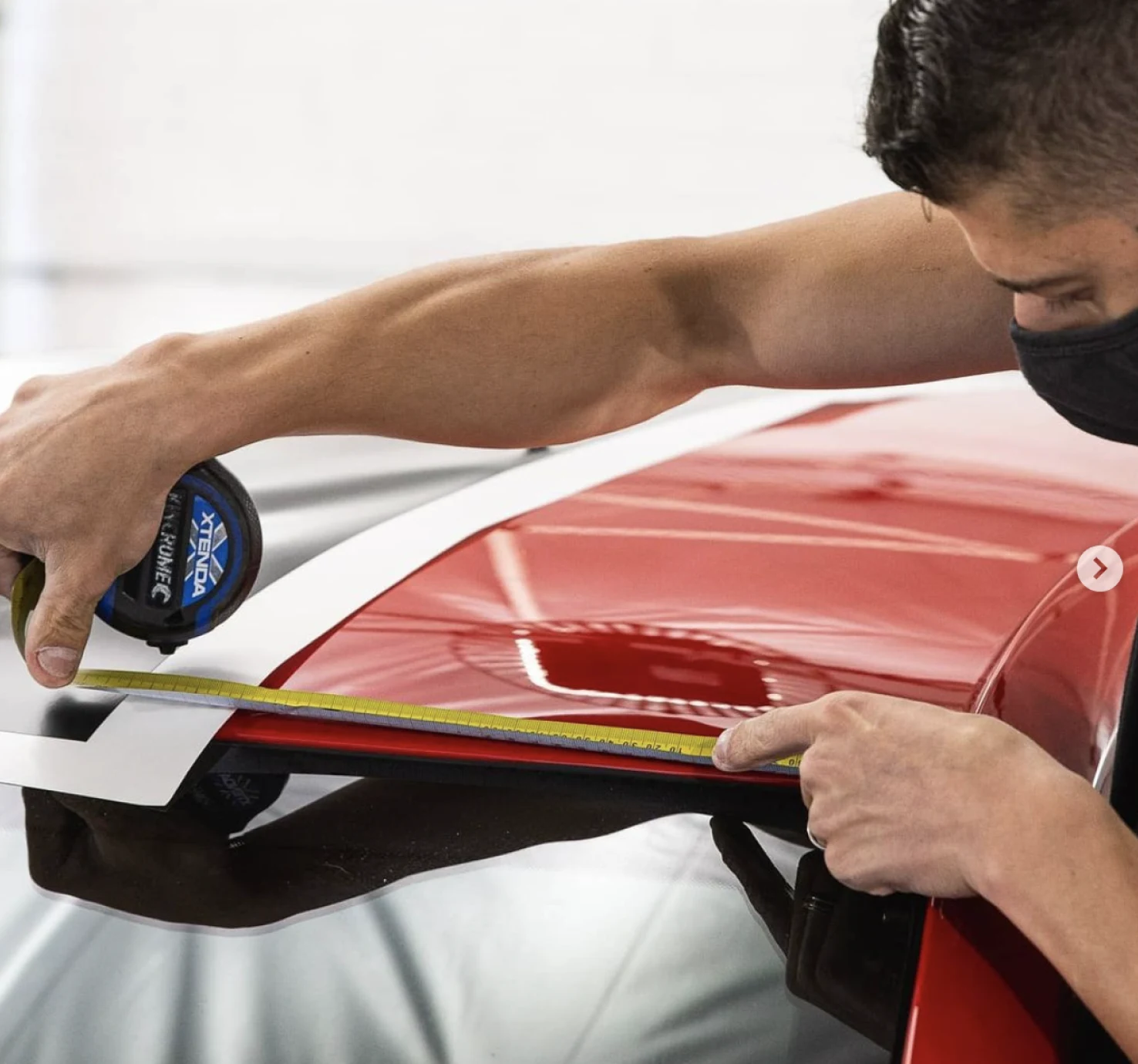 Installer measuring a red panel before applying film