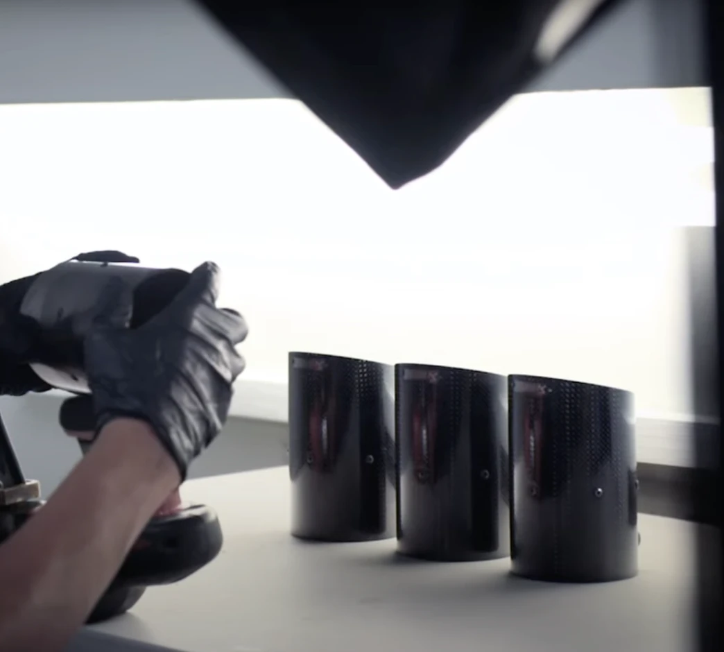 Gloved hands arranging coating bottles under a studio light